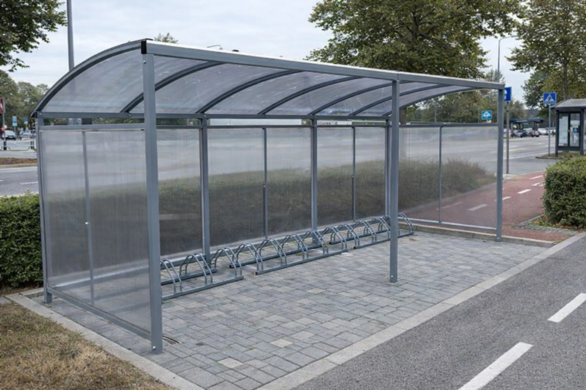 Abri vélo à toiture cintrée en polycarbonate installé en bord de rue